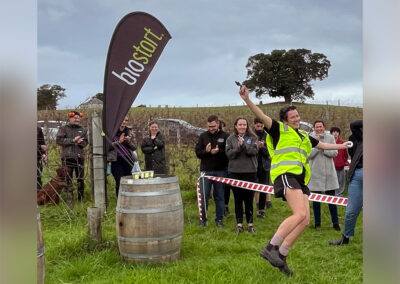A Hortisports competitor jumps for joy in a paddock during an activity.